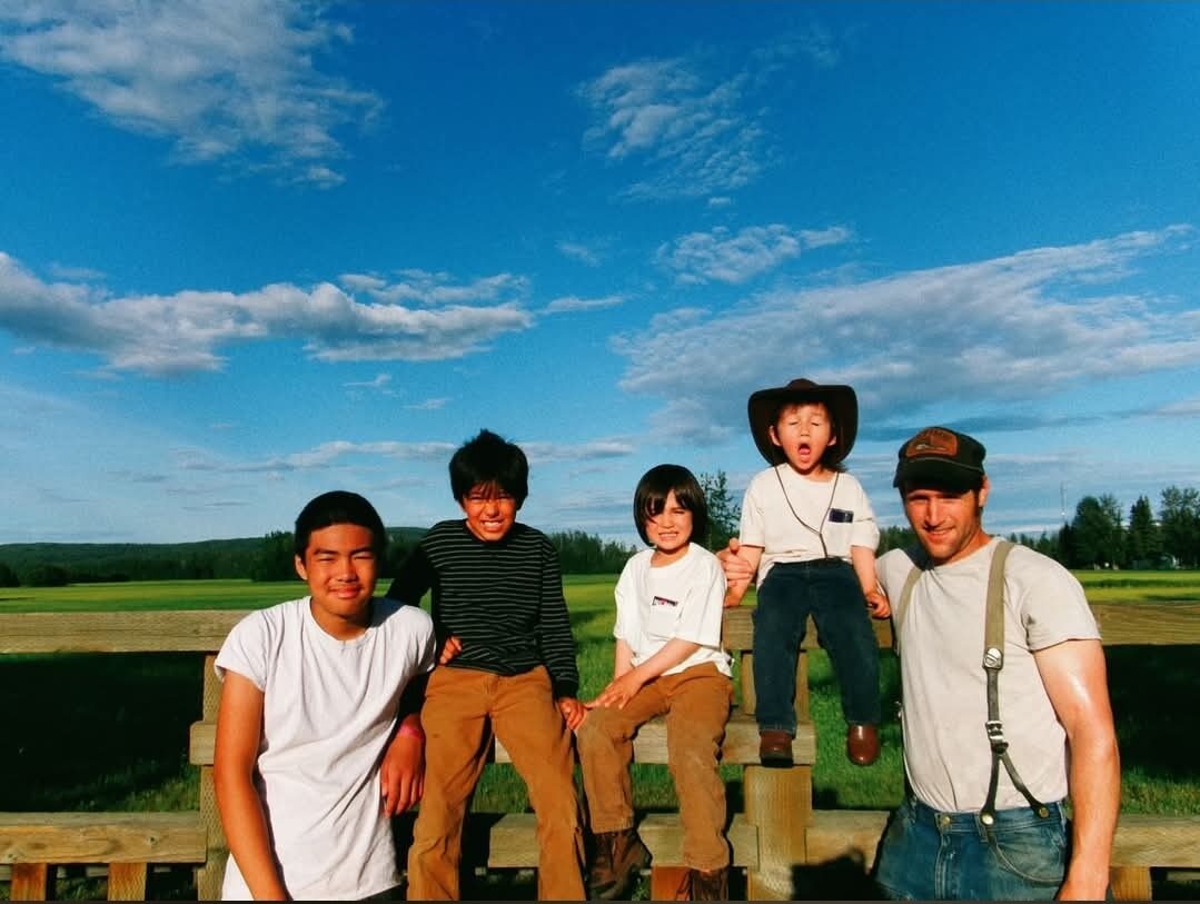 Lee and the kids on the farm fence in Alaska